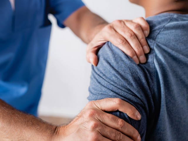 Physical Therapist working on client's shoulder