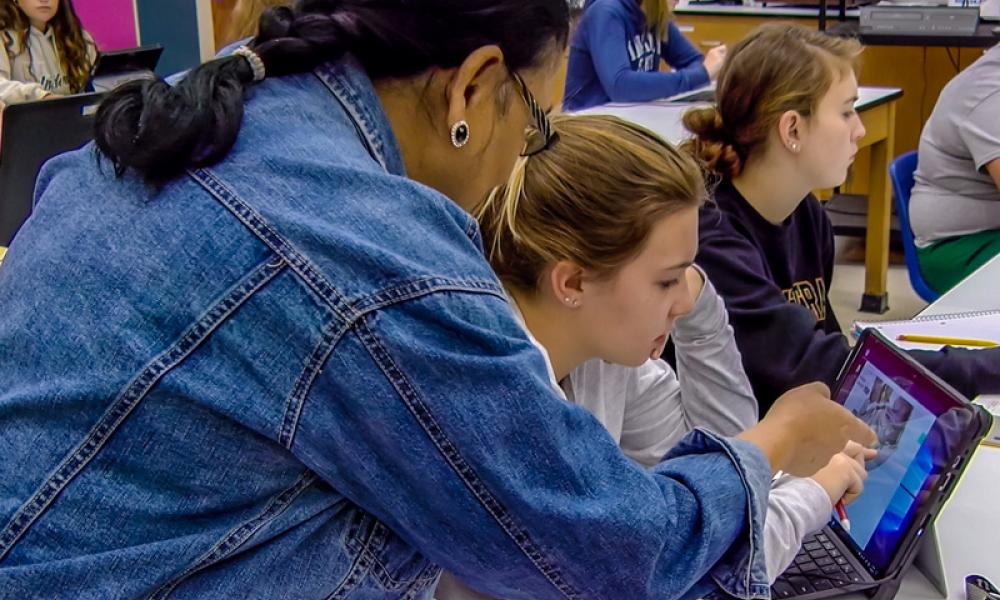 Instructor helping student on computer