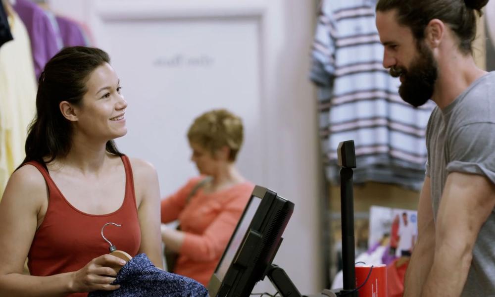 Woman helping man in retail clothing store