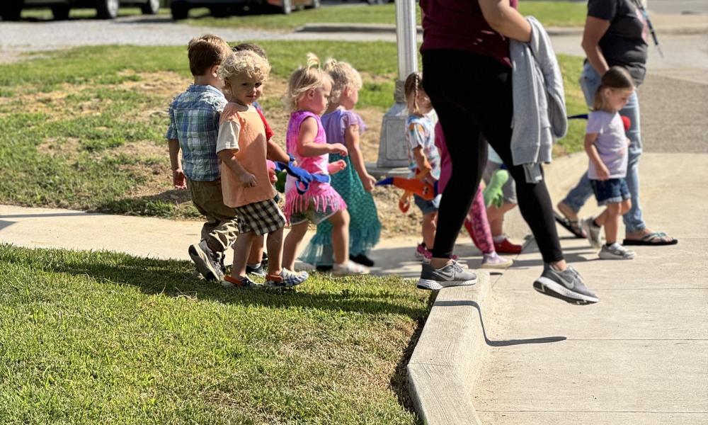 Small World Children with teachers begin to walk across new, donated crosswalk