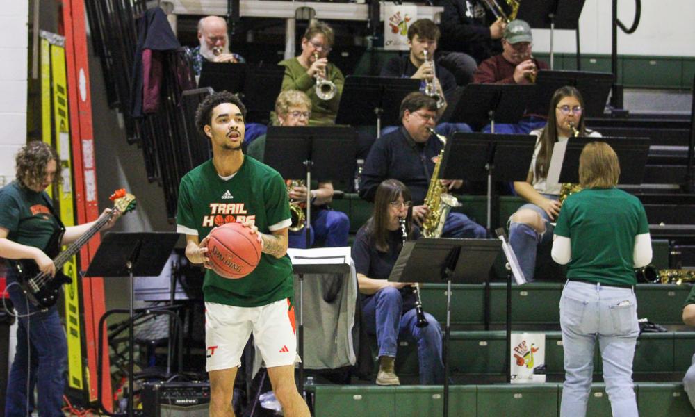 The LTC Pep Band, directed by Jena Combs, energizes the crowd during a home basketball game at Lincoln Trail College. Performing from the stands, the band adds spirit and excitement with live music as players warm up on the court.