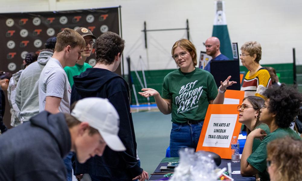 Jena Combs, wearing a T-shirt that says Best Decision Ever, talks with prospective students.