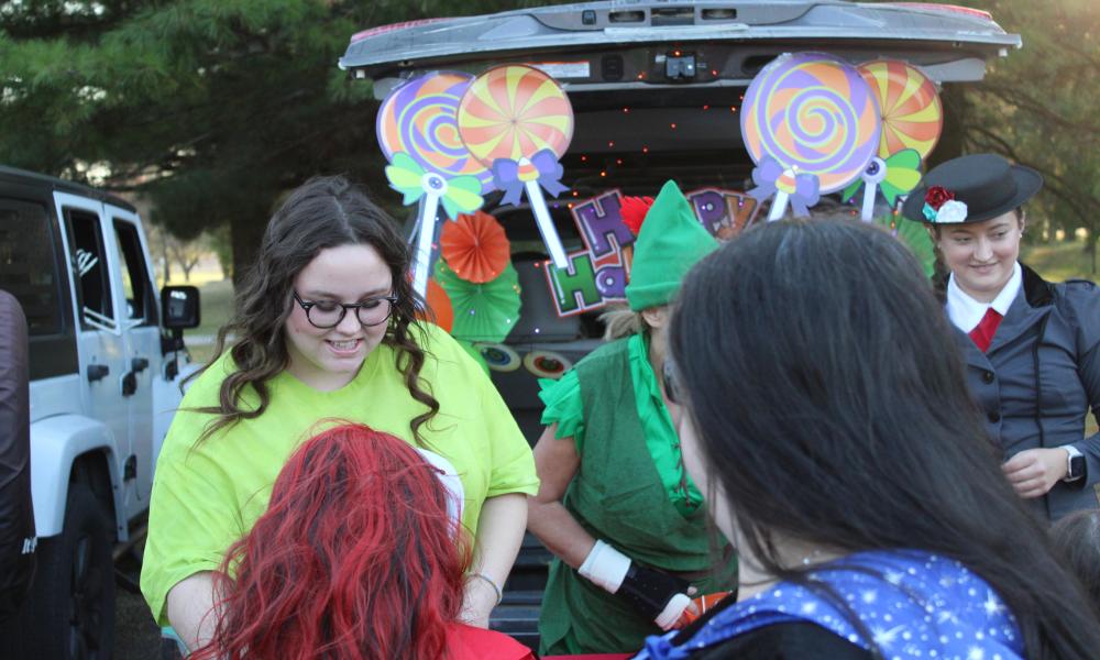 Trunk or Treat 2024-Student dressed as Mike Wazowski passing out candy to community