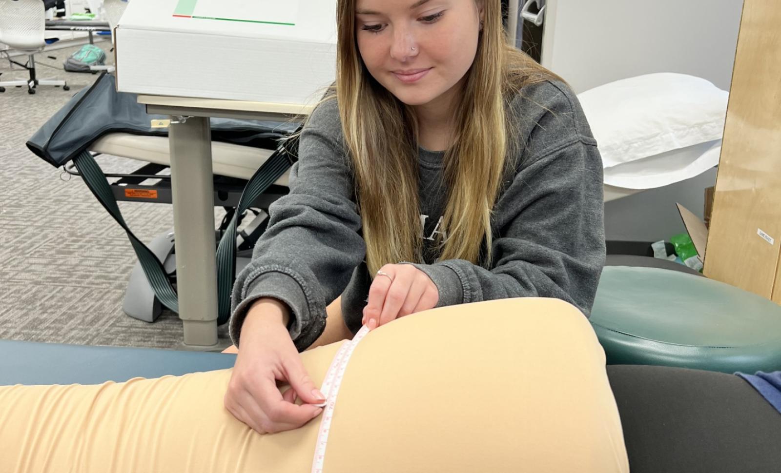 PTA student in lab practicing attending to a patient with Lymphedema