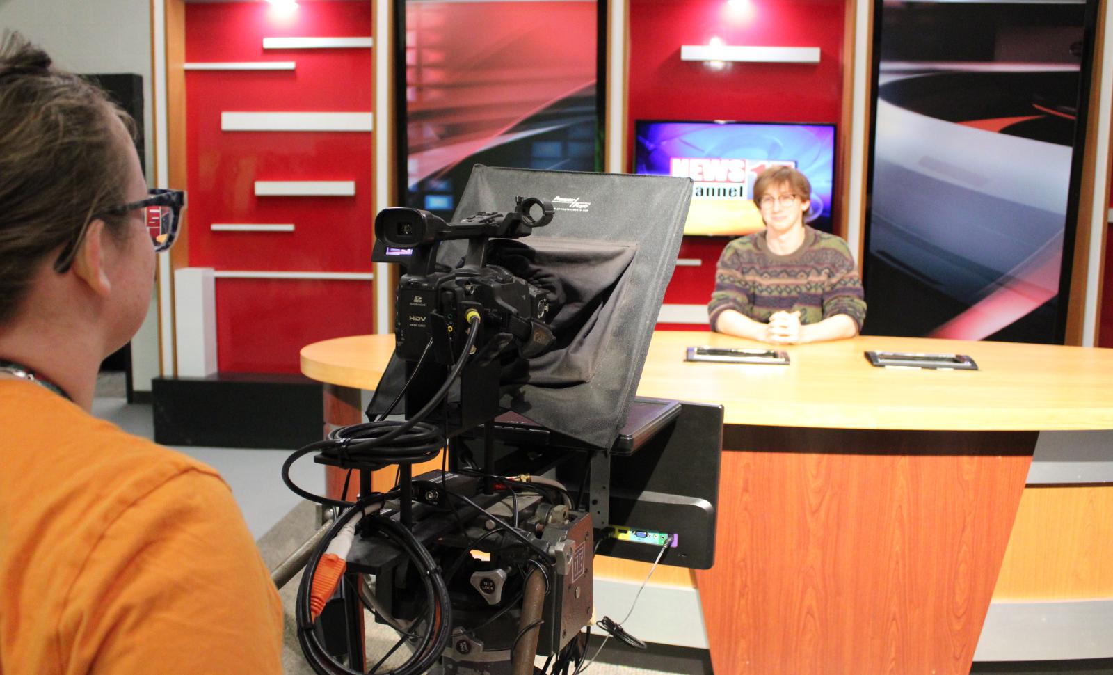 WVC student recording another student behind news station desk.