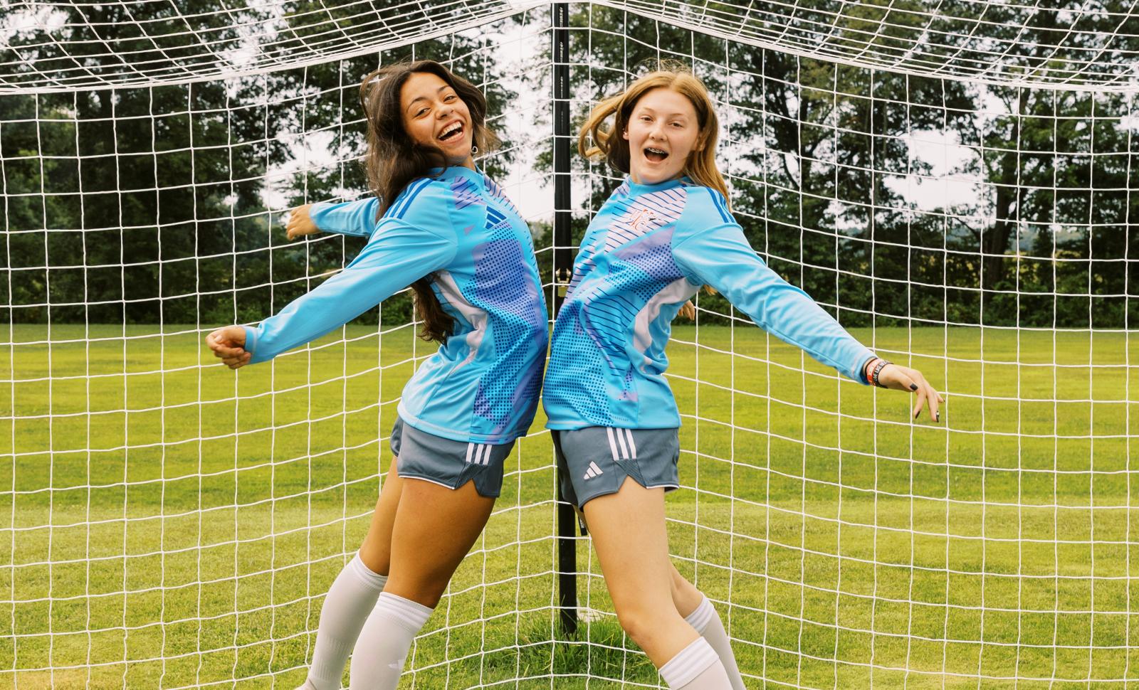 Soccer students jumping and chest bumping mid air