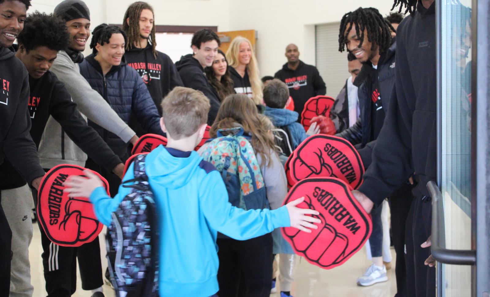 WVC Students stand in line with red foam fists, to fist bump grade school students
