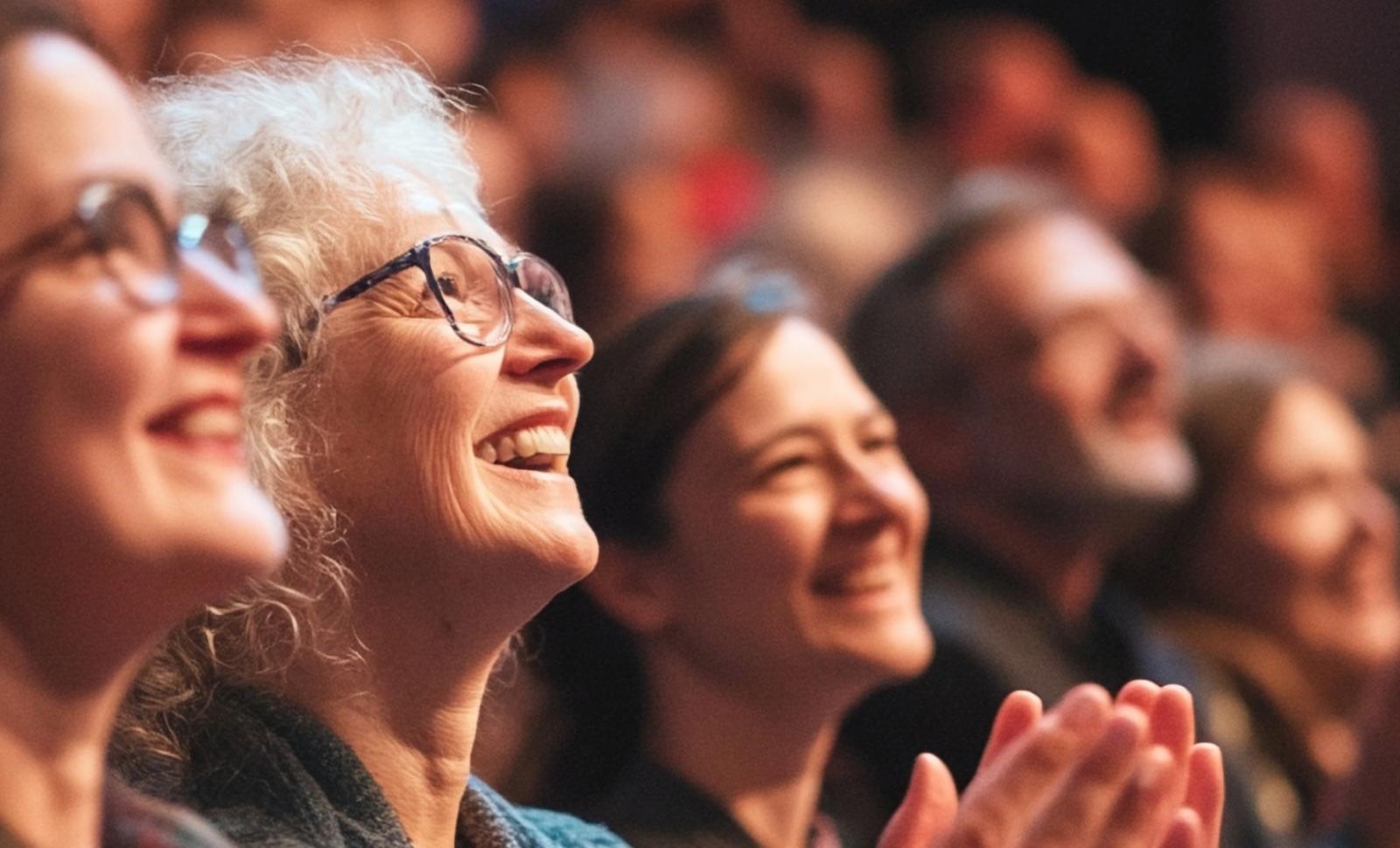 older crowd looking up smiling and clapping