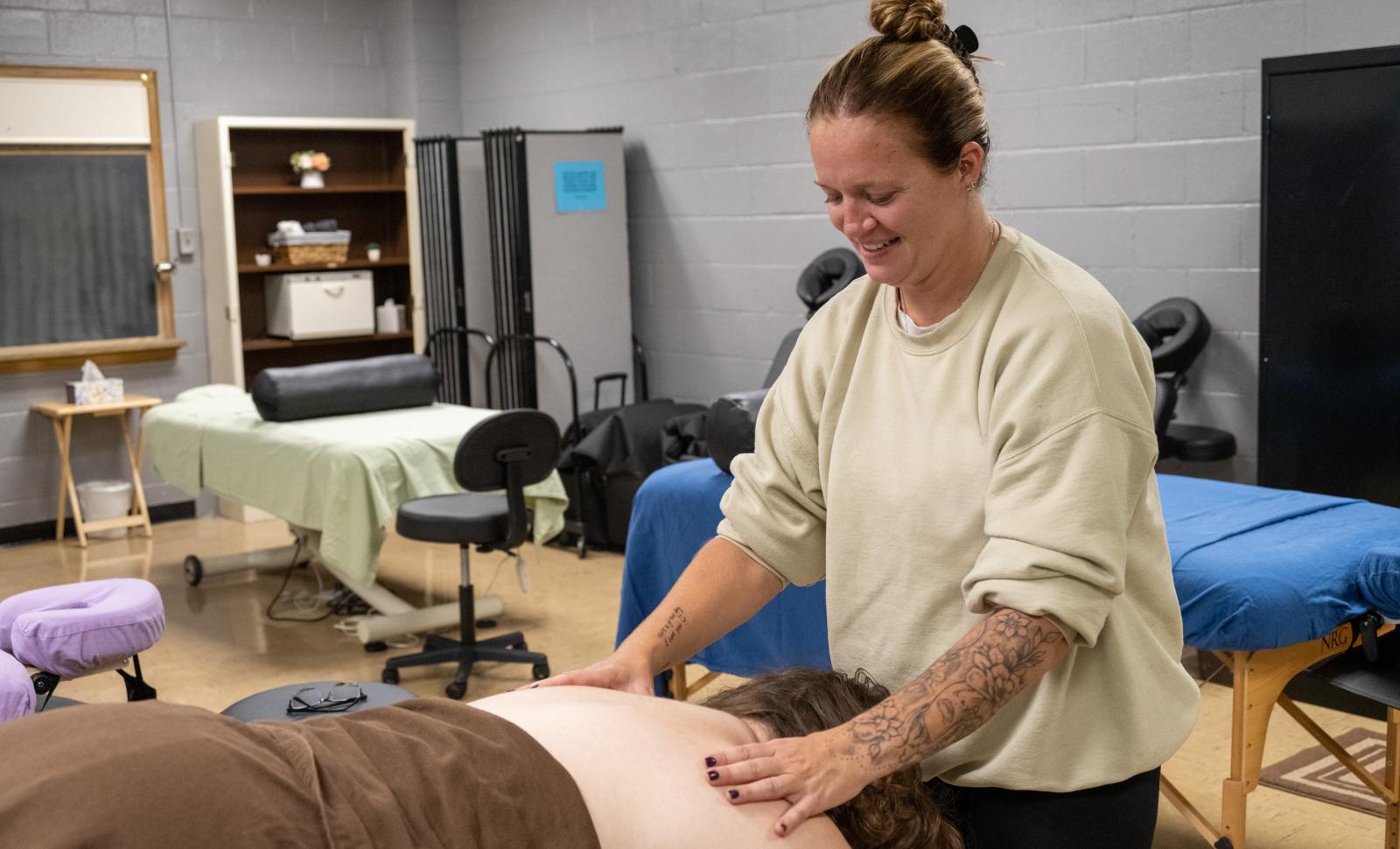 Student practices skills massaging a back