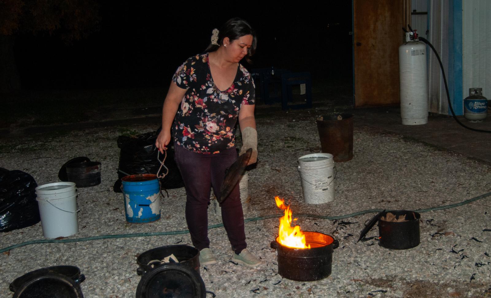 Photo of Instructor demonstrating the Raku firing process.