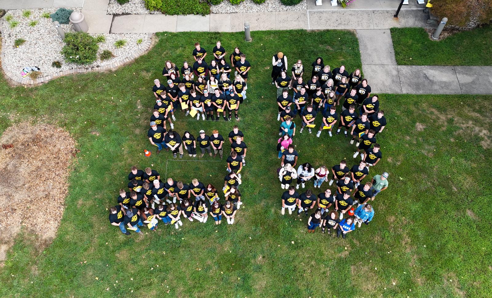 A group of Frontier Community College faculty, staff, and students that spell the number, 50, in front of Student Services..