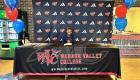 B Waheed Signs with St. John's University with WVC Backdrop and tablecloth