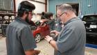 FCC Automotive Lead Instructor Rodney Maxey, right, shows a part to a student in the program.