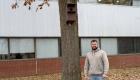 Kyle Kuenstler stands next to the nesting box he built for OCC's white squirells