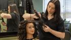 Cosmetology student curls manikin's hair.