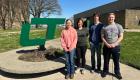 Four Lincoln Trail College students—Hannah Potts, Natalie Ramsey, Korbin Alger, and Dalton Spahn—stand outdoors near a large green LTC logo on a sunny day, smiling for a group photo.