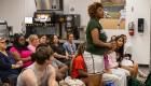 A Lincoln Trail College student stands and introduces herself to the Illinois Eastern Community Colleges Board of Trustees during a board meeting. Fellow First Year Experience students and college employees sit nearby, listening as she speaks in the college’s student lounge.