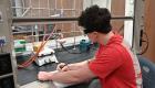 Student works under the fume hood in the chemistry lab.